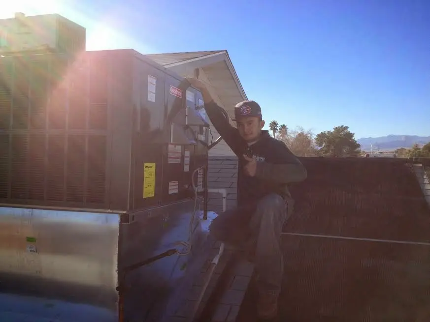 HVAC technician performing Heat Pump Repair on a rooftop unit in Kinderhook